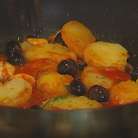 Разогреть в сковороде оставшееся оливковое масло, выложить нарезанный картофель, раздавленный чеснок, оливки и розмарин и обжаривать картофель до золотистого цвета, затем слегка посолить и поперчить, добавить протертые помидоры. Подавать рыбу с картофелем и оливками. 