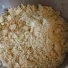 Песочное миндальное тесто: смешать оба вида муки, добавить нарезанное на кубики масло и порубить всё в крошку. 