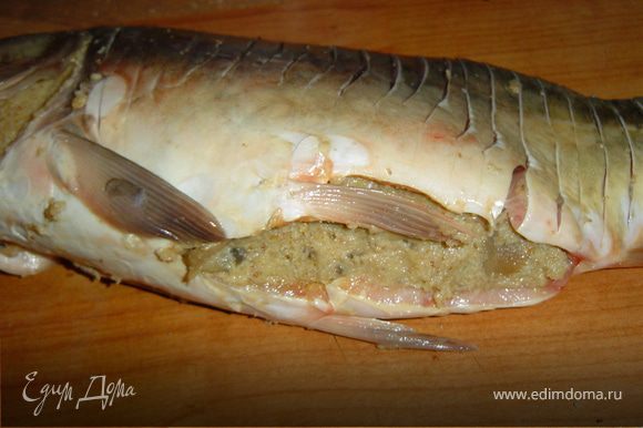 Поперек рыбы делаем надрезы. Заполняем готовым фаршем брюшко рыбы, выкладываем на противень, поливаем растопленным маслом и запекаем в духовке при 170 гр. 25 минут.