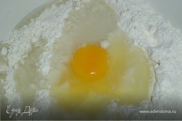 Пока курятина тушится, готовим тесто. К муке добавляем яйцо, воду, немного соли и замешиваем тесто.