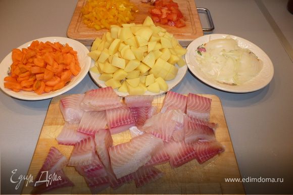 Рыбу режем квадратиками примерно по 4 см, солим, перчим, добавляем рыбную приправу. Картошку режем небольшими кубиками, морковь - кольцами, лук - полукольцами, перец мелкими полосочками или кольцами - как больше нравится. Если используем большой помидор - режем мелкими кубиками, если черри - то половинками или можно оставить целиком. Чеснок не чистим, оставляем целыми зубчиками.