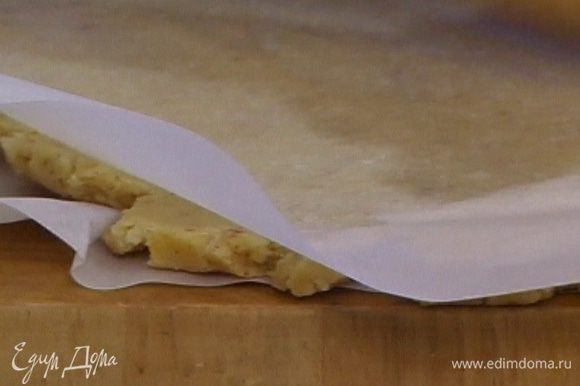 Поместить охлажденное тесто между двумя листами бумаги для выпечки и раскатать.