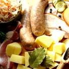 Кислую капусту промыть и обжарить с луком и морковью(если капуста с морковью,то дополнительно морковь можно не добавлять).Обжарить по отдельности колбаски,бекон и корейку,порезанную на куски.Картофель очистить и крупно порезать.В большую жаровню сложить картофель,капусту с луком и морковью,специи,посолить-поперчить и залить бульоном и,по желанию,вином.Довести до кипения и тушить на маленьком огне под крышкой ок.30 мин.Затем добавить мясо,бекон,порезанные колбаски и тушить ещё мин.20-30.Подавать с солениями,укропом,зелёным луком и свежим ржаным хлебом.Приятного аппетита!