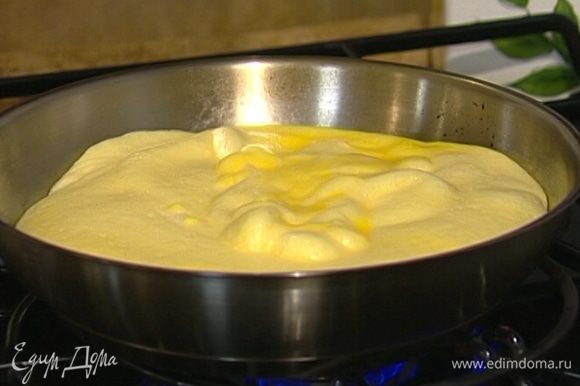 Разогреть сковороду, которую можно ставить в духовку, смазать ее оливковым маслом и выложить яичную массу.