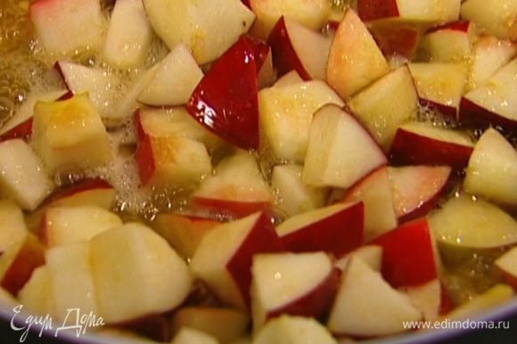 Разогреть в сковороде оливковое и сливочное масло, выложить яблоки, посыпать 3 ч. ложками сахара, перемешать и оставить на огне на 5–7 минут, чтобы яблоки стали мягкими и закарамелизировались, но не превратились при этом в пюре.
