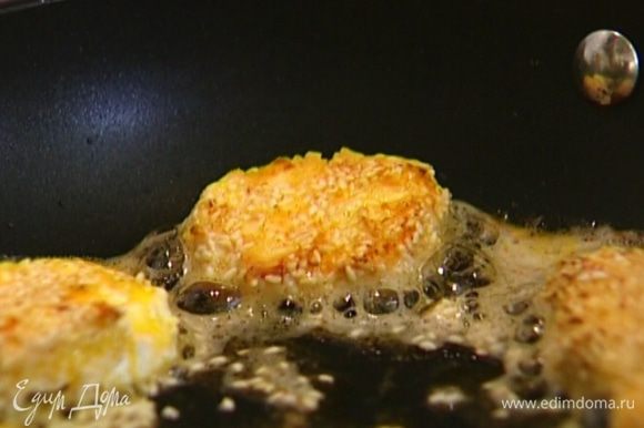 Кусочки сыра обмакнуть в яйцо, обвалять сначала в муке, затем в кунжуте, выложить в сковороду и обжарить до золотистого цвета.