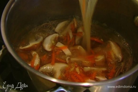 Прогретый бульон с грибами влить в кастрюлю с лапшой, добавить соевый соус и морскую капусту, все перемешать.
