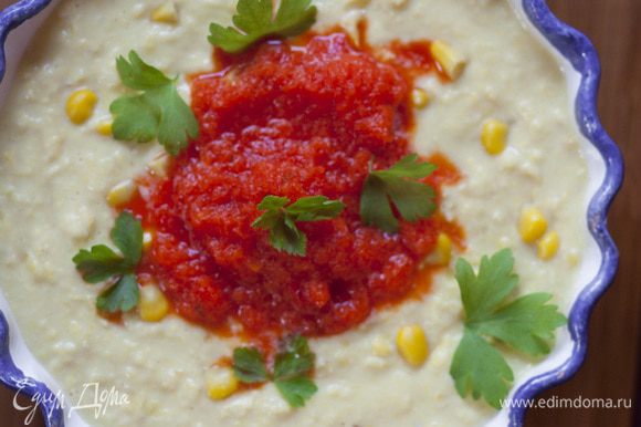 Разлить суп по тарелкам, добавить в каждую столовую ложку пюре из красного перца, посыпать петрушкой.
