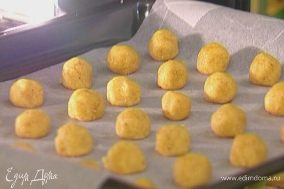 Отщипывая по маленькому кусочку теста, сделать небольшие шарики, выложить их на противень и отправить на 10–15 минут в разогретую духовку.