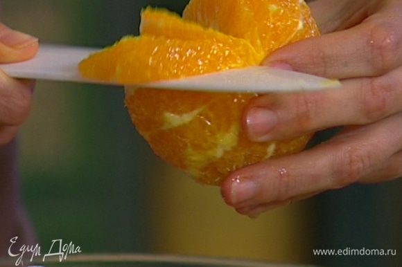 С апельсина срезать оставшуюся кожуру, захватив всю белую ее часть, удалить пленки и разрезать апельсин на сегменты так, чтобы сок капал на руколу.
