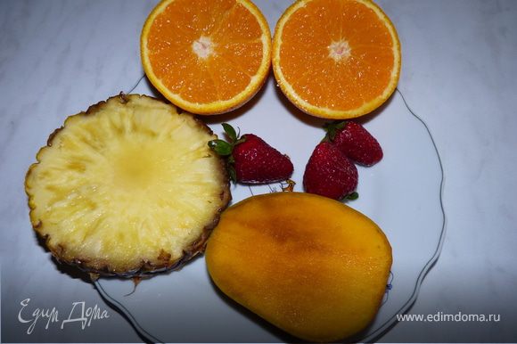 Выжать сок из апельсинов и ананаса. Манго и клубнику выложить в блендер, добавить сок апельсина и ананаса, взбить. Сахар по желанию.