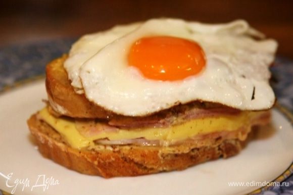 Выложить на тарелку бутерброд, а на него жареное яйцо.