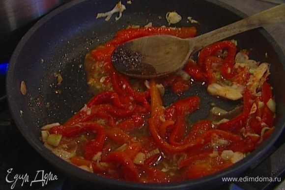 Разогреть в сковороде 1‒2 ст. ложки оливкового масла, выложить перец, помидоры и чеснок, перемешать, посолить и поперчить.
