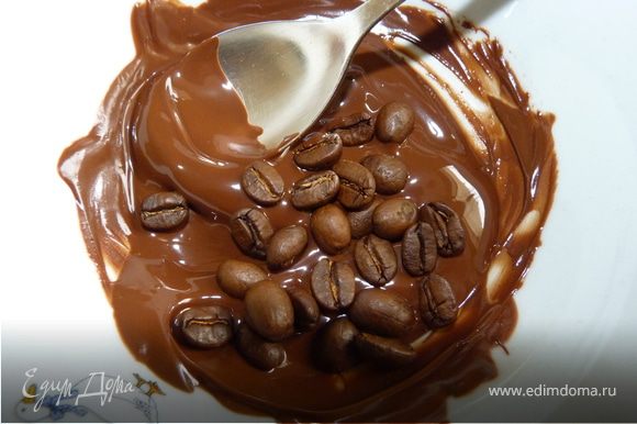 На водяной бане расплавить тёмный шоколад (25г). Положить в него кофейные зёрна, миндаль.