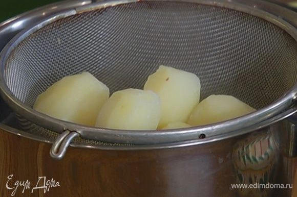 Отваренный картофель почистить и выложить в посуду, в которой вы будете его подавать на стол. Прикрыть крышкой, чтобы он не остыл.