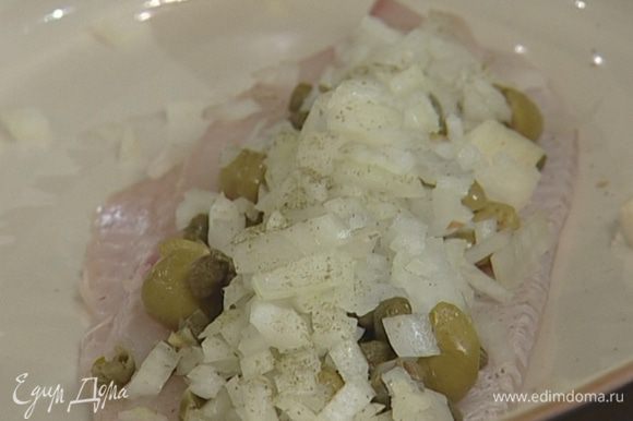 В жароупорную посуду уложить 2 филе рыбы, сверху — лук с оливками, каперсами и чесноком, посолить.