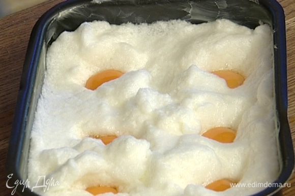 Выложить в получившиеся углубления желтки. Поперчить, слегка присыпать натертым сыром, сверху положить по небольшому кусочку масла. На самом нижнем уровне разогретой духовки запекать яйца 15–20 минут.