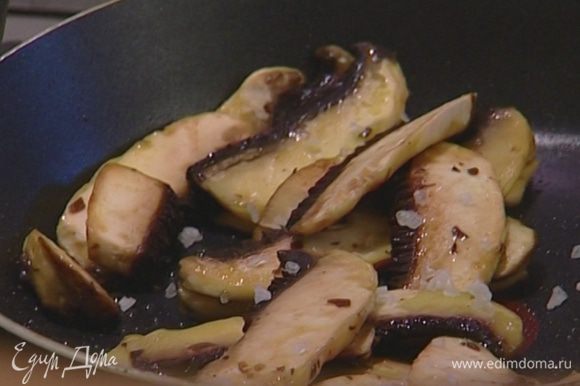Разогреть в сковороде 2 ст. ложки оливкового масла и обжарить грибы, сразу же посолив и поперчив их.
