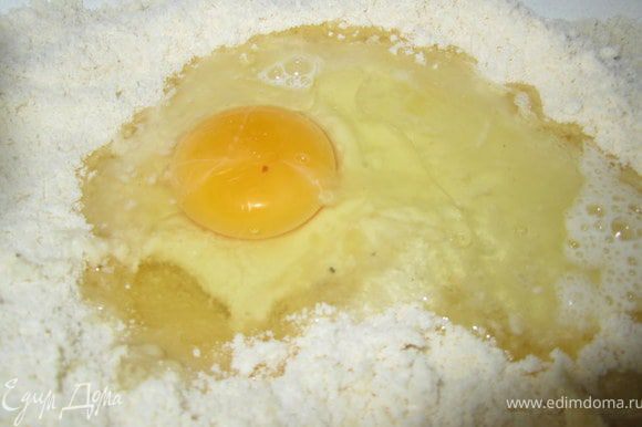 Сделать углубление, добавить яйцо растительное масло, соль, воду.