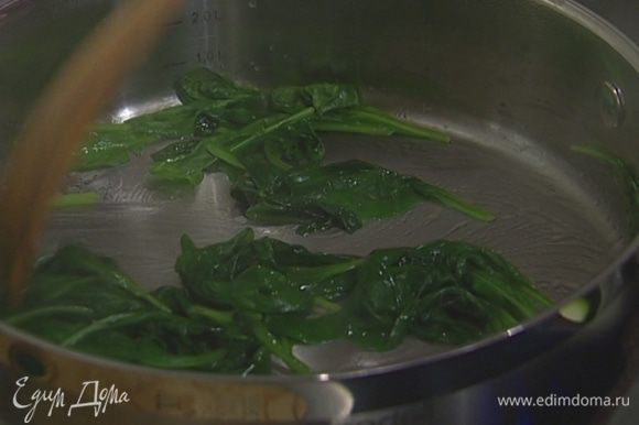 В глубокой сковороде разогреть 1 ст. ложку оливкового и 1 ч. ложку сливочного масла, отправить в нее шпинат. Накрыть сковороду крышкой и томить шпинат 2–3 минуты.