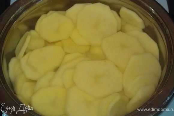 Очищенный картофель нарезаем тонкими кружочками и заливаем холодной водой.