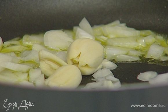 Приготовить соус: в тяжелой сковороде разогреть 3–4 ст. ложки оливкового масла и обжарить лук и чеснок до прозрачности.