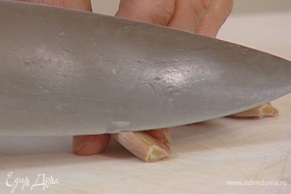 Два зубчика чеснока почистить и раздавить плоской стороной ножа.