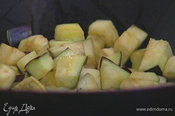 Разогреть в сковороде вок растительное масло и обжаривать баклажаны 10–15 минут, постоянно помешивая.
