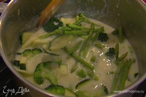 Как только суп снова закипит, всыпать зеленый горошек и варить еще минуту. Влить сливки и прогреть суп, но не кипятить.