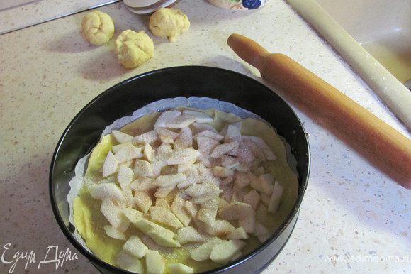 Яблоки (и груши, если вы их используете) чистим и нарезаем тонкими дольками в миску. Сбрызгиваем соком 1 лимона, чтобы не потемнели. Дно формы смазываем маслом и выкладываем 1-й корж (который раскатали на пергаменте). Смазываем его растопленным сливочным маслом, выкладываем третью часть нарезанных яблок по всей поверхности. Посыпаем сахаром, корицей и (или) мускатным орехом или спесью специй для выпечки.
