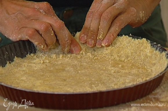 В невысокую, смазанную оставшимся маслом форму для выпечки выложить тесто, распределяя его равномерно по дну формы, сделать бортик.