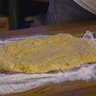 Присыпать рабочую поверхность мукой, выложить тесто, слегка распластав его. 