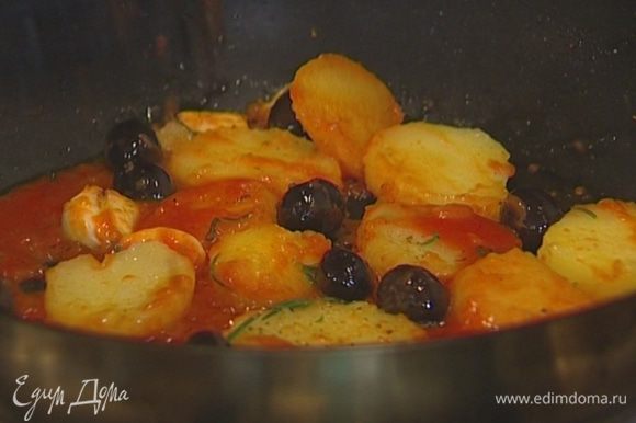 Разогреть в сковороде оставшееся оливковое масло, выложить нарезанный картофель, раздавленный чеснок, оливки и розмарин и обжаривать картофель до золотистого цвета, затем слегка посолить и поперчить, добавить протертые помидоры. Подавать рыбу с картофелем и оливками.