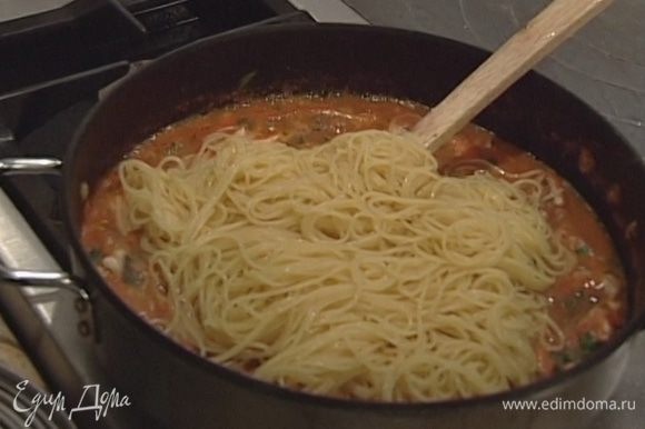 Спагетти отварить в подсоленной воде и откинуть на дуршлаг, затем выложить в сковороду к соусу и все перемешать.