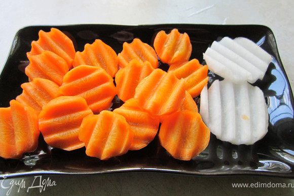 Морковь и дайкон порезать кружочками, добавить в суп, варить 10 минут.