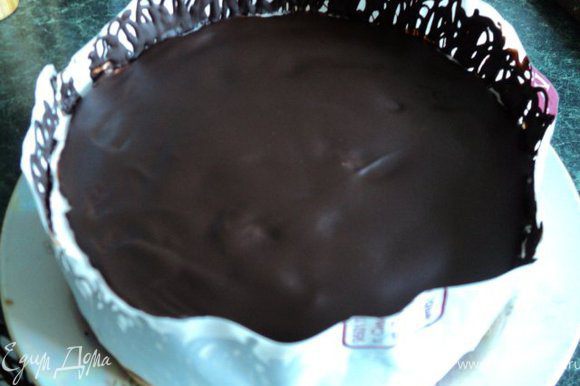 Для украшения растопить в микроволновке или на водяной бане поломанную на кусочки плитку шоколада, выложить растопленный шоколад в полиэтиленовый пакетик, срезать кончик уголка и выдавливая, нанести на полоску из бумаги для выпечки или плотного полиэтилена ( по длине окружности торта и высотой 7-8см) зигзагообразные линии. Дать шоколаду немного схватиться и обернуть лентой торт. Поставить в холодильник до полного застывания шоколада.