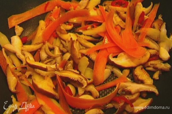Разогреть в воке оливковое масло и обжаривать грибы, морковь, имбирь и чеснок в течение 2 минут.