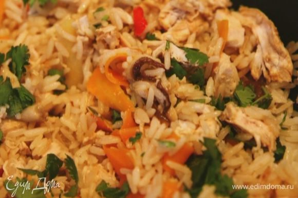 Когда рис будет готов, добавить курицу и 2/3 нарубленной кинзы, влить соевый соус, перемешать и посыпать оставшейся кинзой.
