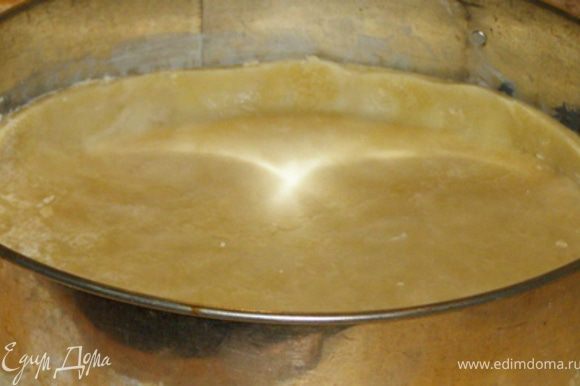 Раскатать тесто в скалкой в пласт толщиной 1/2 см и уложить в круглую форму диаметром 25-35 см.