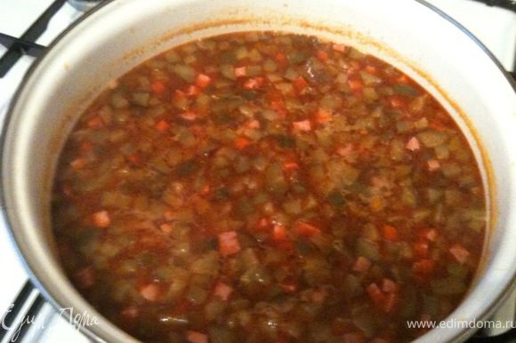 В кипящую воду выложить мясо-луково-огуречно-томатную смесь и уменьшить огонь. Посолить, добавить специи. Варить около 20 минут.