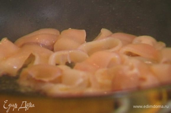 Разогреть в другой сковороде 1 ст. ложку оливкового масла и обжаривать кальмары 2 минуты, непрерывно помешивая.