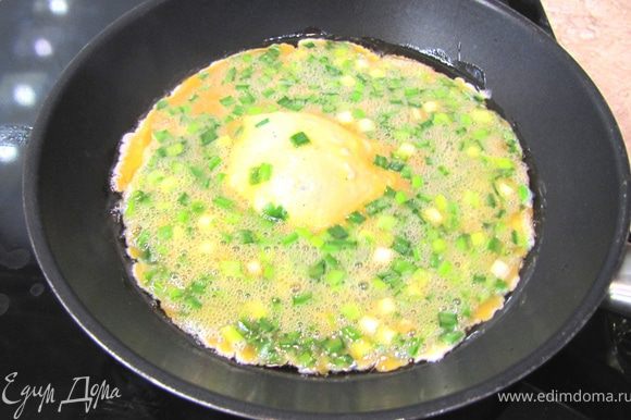 Разогрейте растительное масло на сковороде на среднем огне. Когда масло нагреется вылейте смесь яиц и лука в сковороду. Яичница сразу должна скворчать.