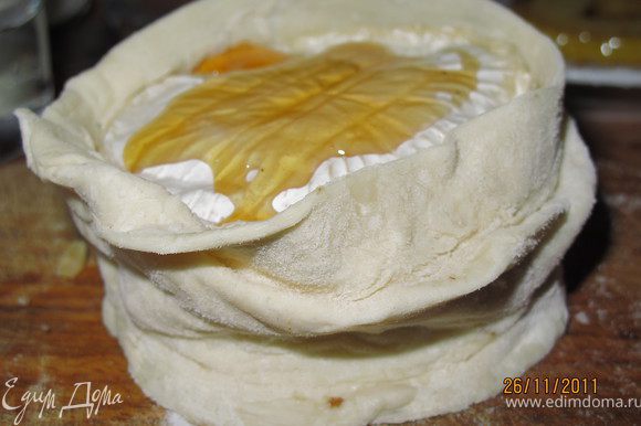 Сверху накрываем сыром с плесенью, обмазываем его мёдом. Оборачиваем наш десерт тестом, края смазываем водой и залепляем.