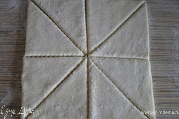 Разморозить слоеное тесто, присыпать мукой с двух сторон, нарезать на порционные треугольники.