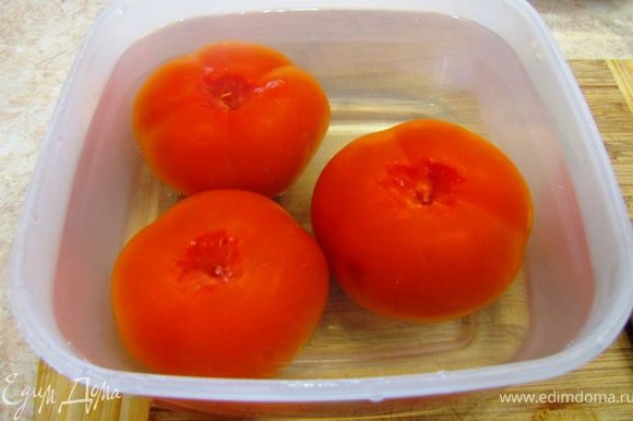 Возьмите помидоры и вырежьте плодоножку. Залейте помидоры кипятком на несколько минут. Можете положить их в кастрюлю с кипящей водой. Кроме того, помидоры можно потереть довольно сильно тупой стороной лезвия ножа до потемнения. В любом из этих случаев кожица будет легко слезать с овоща. Снимите кожицу с помидоров.