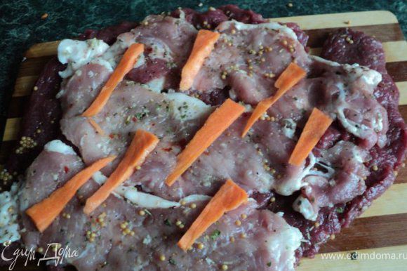 Выложить прямоугольником пласты говядины ( слегка внахлест), посыпать желатином. Затем выложить пласты из свинины, посыпать желатином. Сверху разложить тонко порезанные полоски моркови.