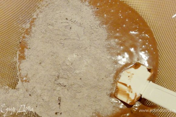 Смесь муки с какао-порошком постепенно добавить в шоколадно-желтковую массу.