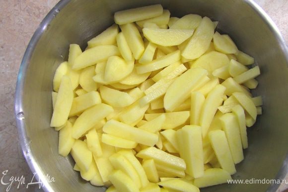 Почистите картофель, кладите картофель в емкость с водой и с небольшим количеством лимонного сока, чтобы он не потерял цвет. Нарежьте картофель как для жарки: небольшие клубни пополам вдоль и потом поперек толщиной 5 миллиметров.