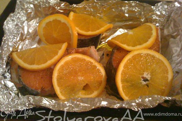 Апельсин вымыть и нарезать кружками вместе с кожурой. Семгу посыпать орегано, тимьяном, посолить, поперчить и выложить в жаропрочную форму. Взбрызнуть рыбу оливковым маслом, обложить кружками апельсина и оставить мариноваться на 20-30 минут.