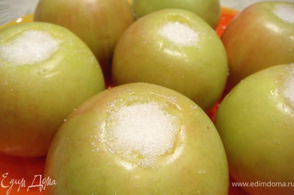 Яблоки вымыть, удалить сердцевину, не прорезая их насквозь. Засыпать внутрь каждого яблока по 1 ст.л. сахара. Отложить на 10 мин.